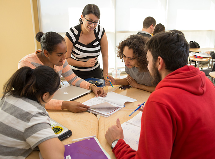 Accounting students work together at a table in the library.