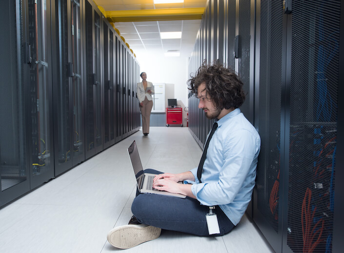 Team of server technicians work in data center.