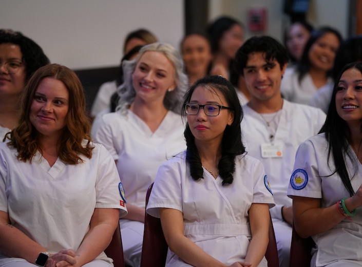 An LVN instructor demonstrates a concept to young LVN female nursing students.