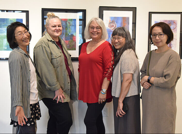 group of women in front of paintings