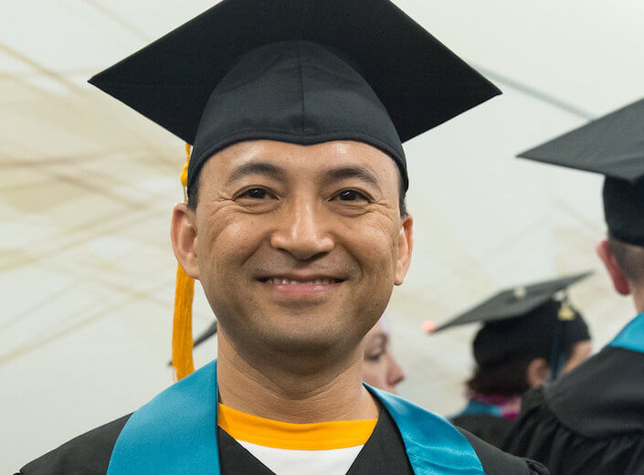 Older male graduate in cap and gown.