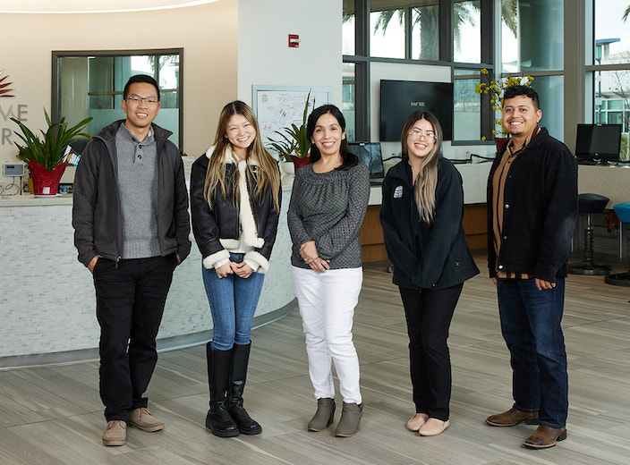 Admissions and Records staff standing in front of the Welcome Center service desk in SEC.