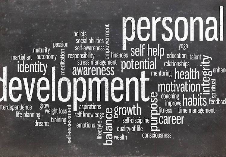 Personal Development word cloud written on a blackboard in white chalk.