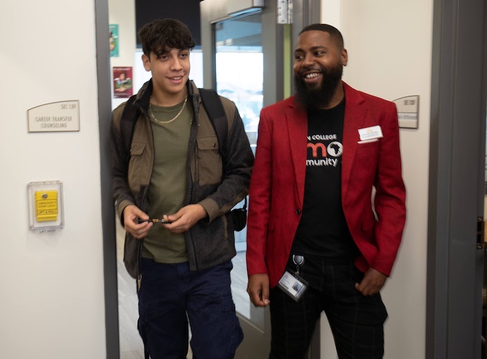 Roshawn Walters walks with a male student through the Counseling office.