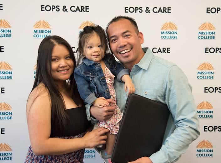 CalWORKs family standing in front of "step and repeat" during event.