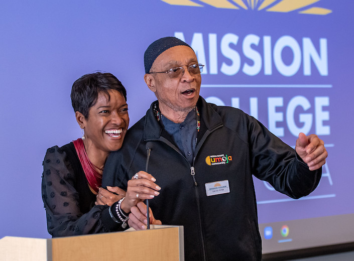 Yolanda Barnes and Dr. Piper at podium smiling during Black History Event for Umoja program.