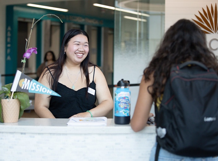 Welcome Center Ambassador smiles as she assists a fellow student at the Welcome Center.