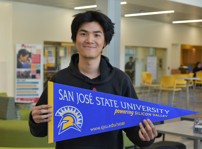 Young Asian-American man holds SJSU pendant.