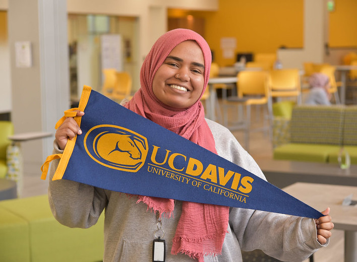 Student holds UC Davis pendant.